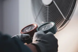 HVAC system service technician using measuring gauge checking refrigerant 